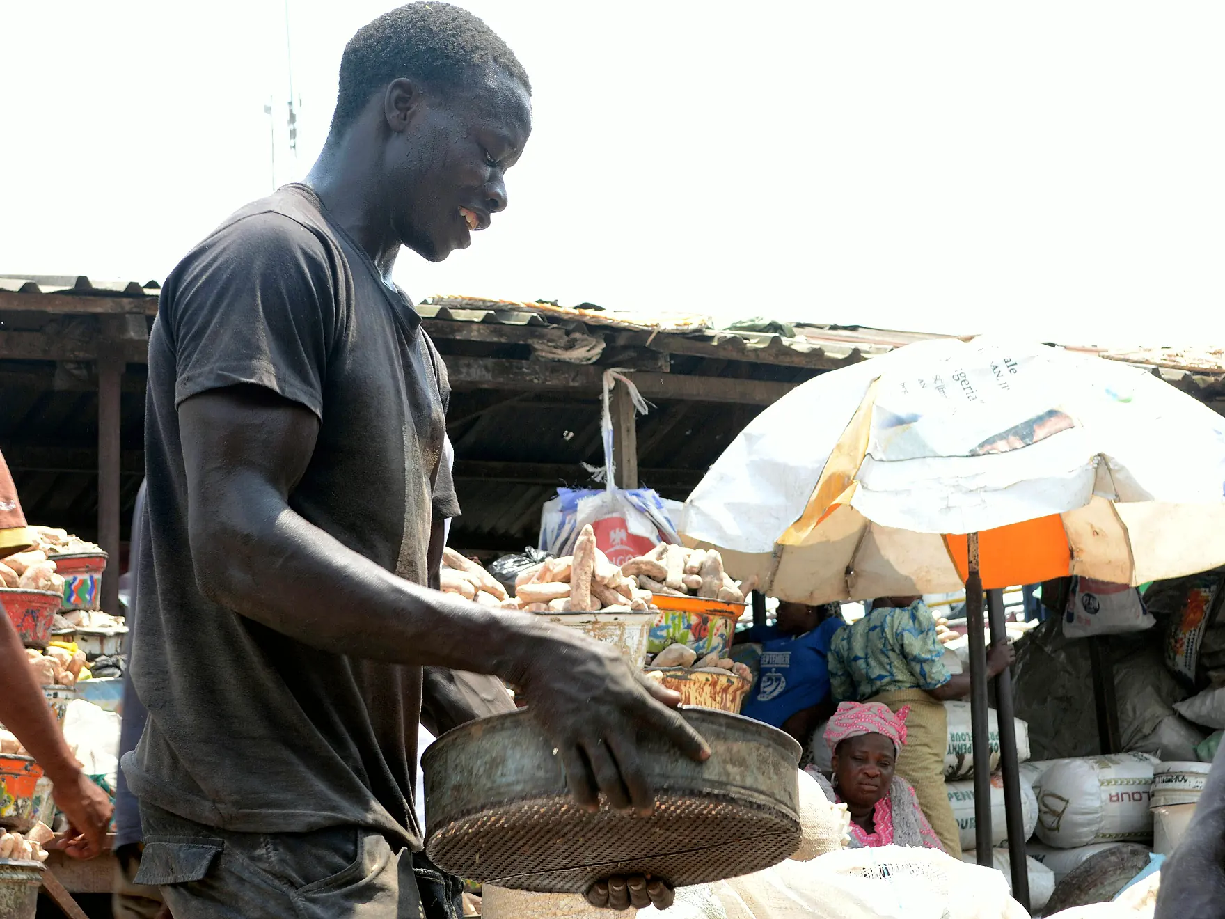 A trader weighing goods at his stall in a Nigerian market